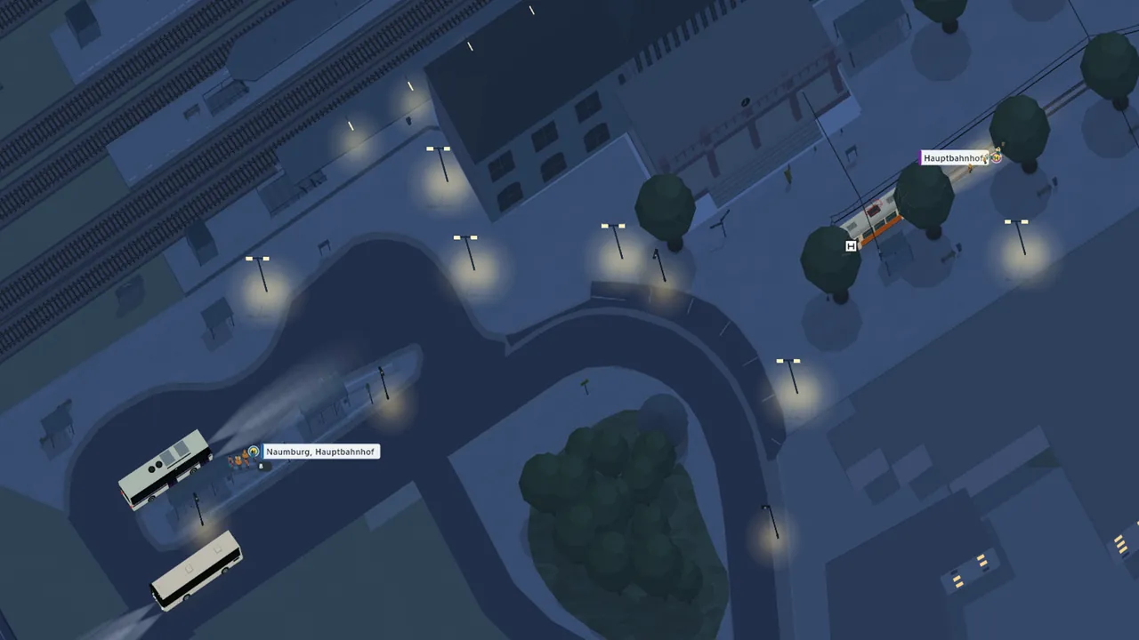 Naumburger Hauptbahnhof bei Nacht mit leuchtenden Laternen, einer Straßenbahn an der Haltestelle und zwei Bussen mit eingeschaltetem Licht.