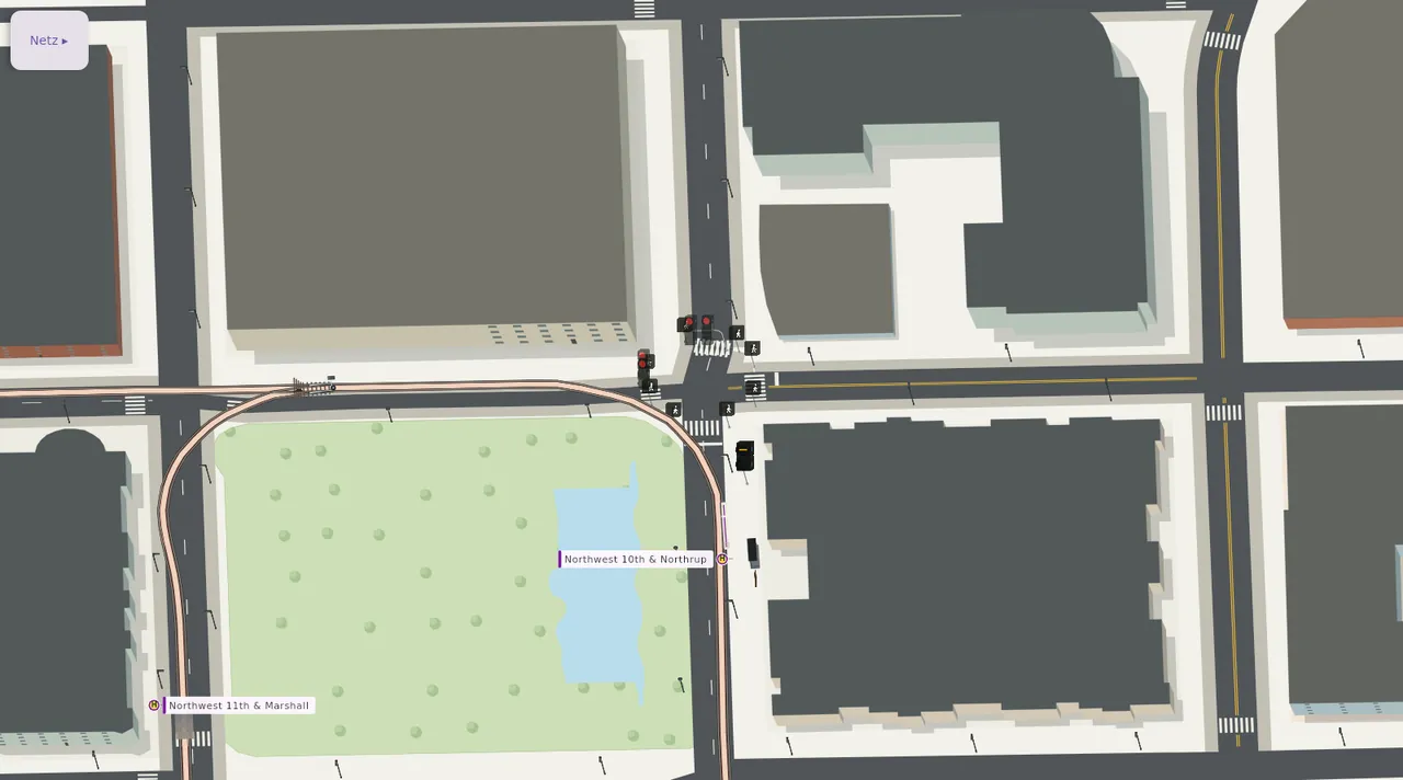 Streetcar-Schleife um einen Park mit Wasserbecken; an der Kreuzung stehen amerikanische Ampeln und Streetcar-Signale.